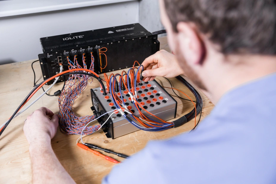 expert technician connects cables for low-current tests